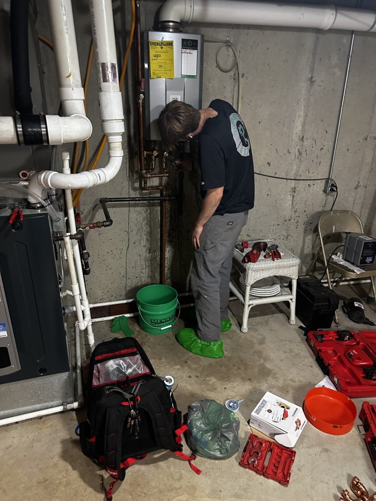 Plumber servicing a tankless water heater