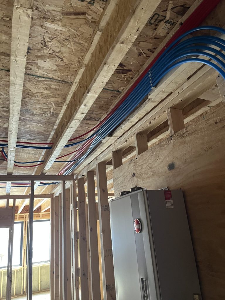 PEX plumbing installation with red and blue water lines.