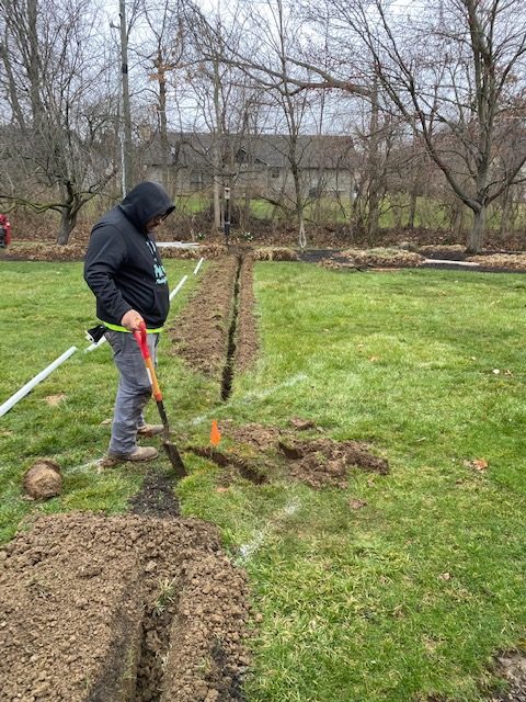 Plumber digging trench for a pipe installation