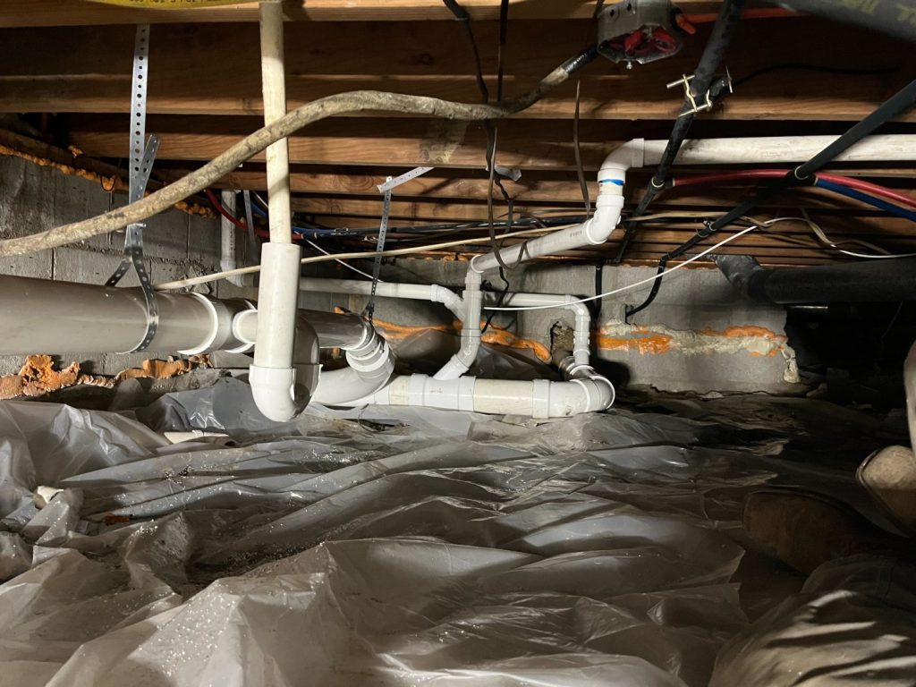 Plumbing pipes and drain lines installed in a crawl space