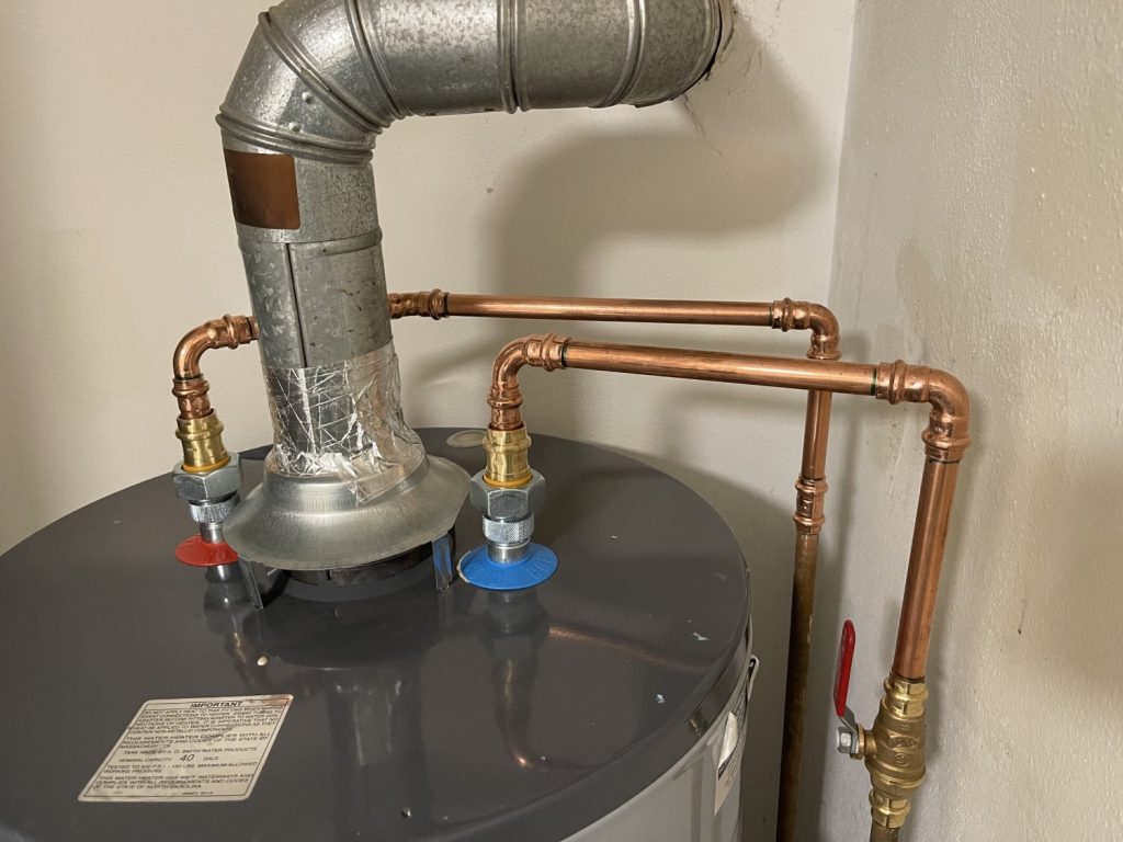 Closeup of pipe fittings on a gas water heater