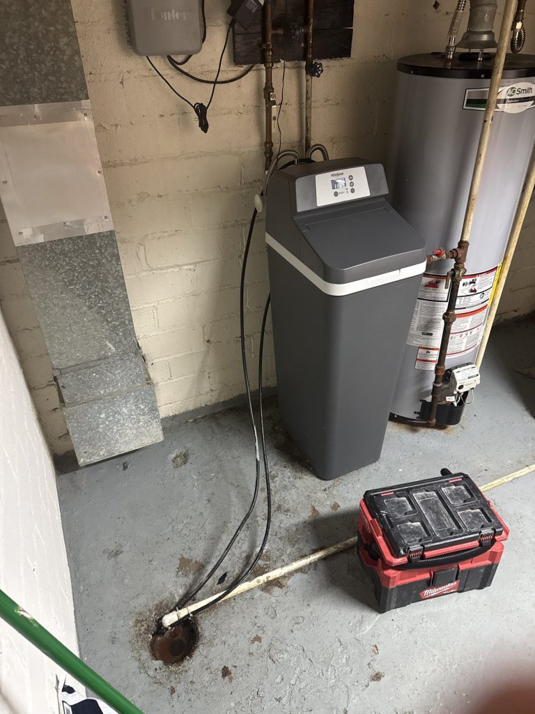 Recently installed water softener next to a water heater.
