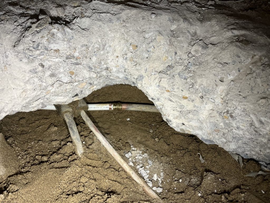 Broken slab exposing pipes with leaks.