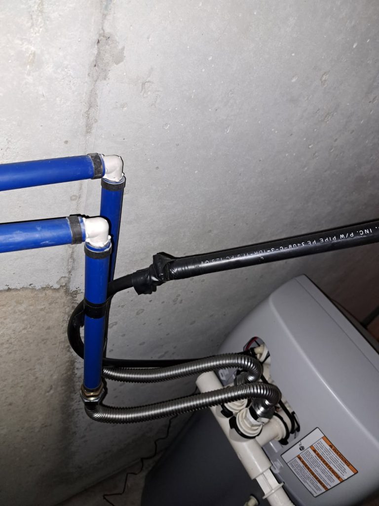Closeup of the water lines connected to a water softener.