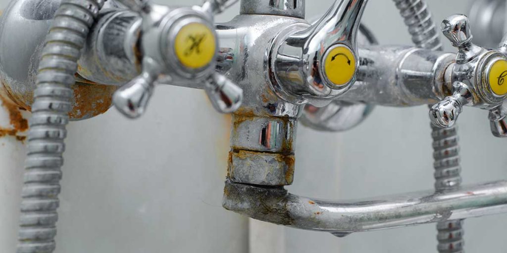Chrome bathroom faucet showing heavy mineral buildup, rust, and limescale deposits from hard water affecting a Noblesville home plumbing system.