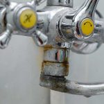 Chrome bathroom faucet showing heavy mineral buildup, rust, and limescale deposits from hard water affecting a Noblesville home plumbing system.